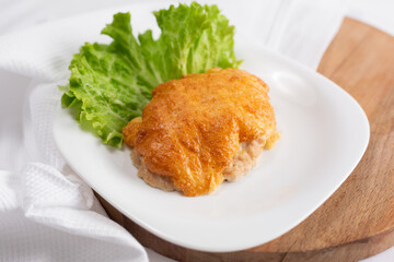 plate with chicken breast baked under cheese