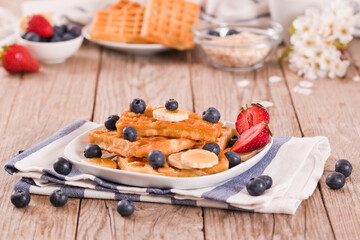 Obraz na płótnie Canvas Waffles with blueberries, bananas and honey.