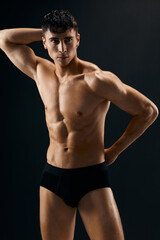 Fototapeta premium handsome man with muscled naked body in dark panties cropped view studio