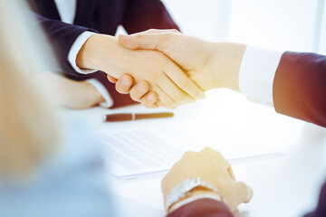 Businesspeople or lawyers shaking hands finishing up meeting or negotiation in sunny office. Business handshake and partnership