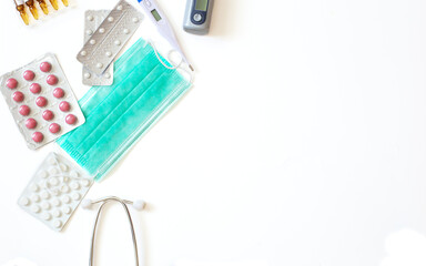 Medical background with pills, medical mask, thermometer and stethoscope