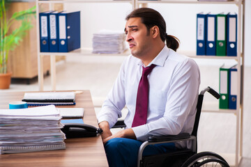 Young male employee after accident in wheel-chair at workplace