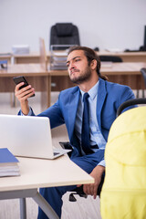 Young male employee looking after new born at workplace