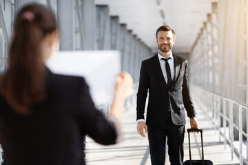 Female representative meeting business partner in airport