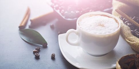 Coffee beans with green leaves for cooking. Bag of coffee. Coffee beans roasted on the table.