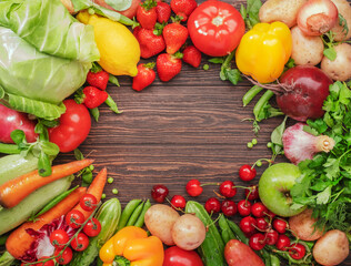 Healthy food. Assortment of fresh summer organic vegetables, fruits and berries on wooden table background