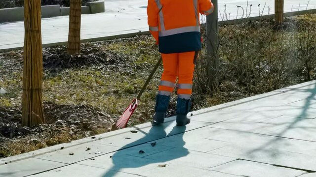 Cleaning Leaves In The City, Janitor Woman Sweeping The Foliage In Spring Park. A Street Sweeper With Rake In Moscow, Work Of Housing And Communal Services