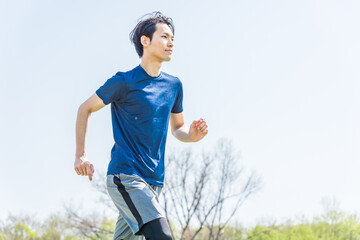 公園でランニングをする若い男性