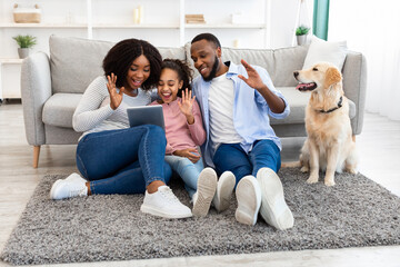Black family having videocall using laptop waving hands