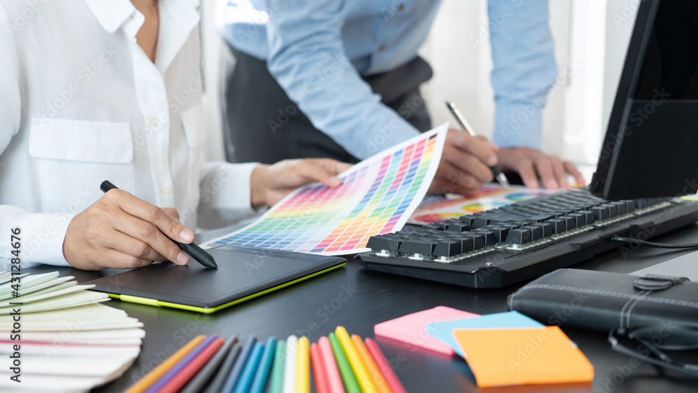 Aufkleber graphic designer or creative working together coloring using graphics tablet and a stylus at desk wi