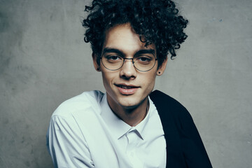 young guy with glasses curly hair jacket shirt portrait close-up