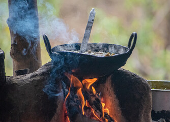 food cooking in a traditional indian culinary utensils kadhai on a choolah