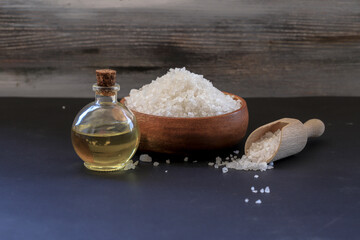 Fototapeta na wymiar Natural rock salt on the table and massage oil obtained from salt in a bottle. Spa