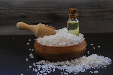 Fototapeta na wymiar Natural rock salt on the table and massage oil obtained from salt in a bottle. Spa