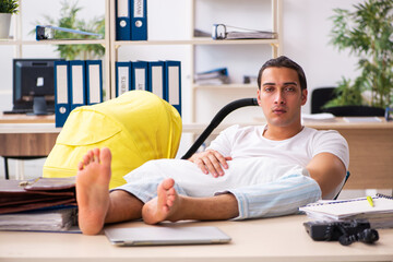 Young male employee looking after newborn at workplace