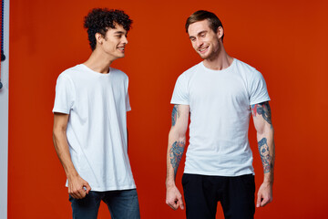 two friends in white t-shirts stand side by side isolated background