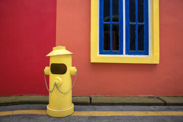 Colorful background of yellow fire hydrant in front of the house building