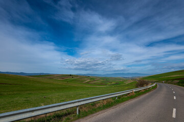 Green valley near asphalt road at springtime in Transylvania, Romania.