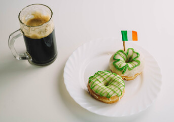 Imagen de un desayuno irlandes para celebrar san patricio, compuesto por dos donuts caseros y una jarra de cerveza negra.