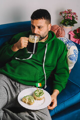 Un hombre soltero desayunando rosquillas y cerveza negra para celebrar el Día de San Patricio
