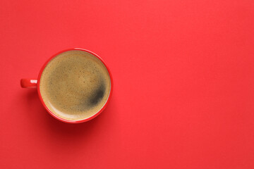 Cup of aromatic coffee on red background, top view. Space for text