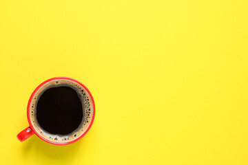 Aromatic coffee in red cup on yellow background, top view. Space for text
