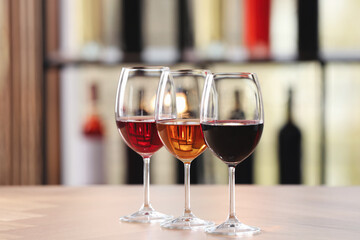 Different sorts of wine in glasses on table indoors