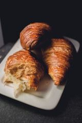 Three croissants on a white plate, rustic style