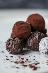Homemade vegan peanut energy chocolate candy truffles with almonds and coconut flakes topping, close up