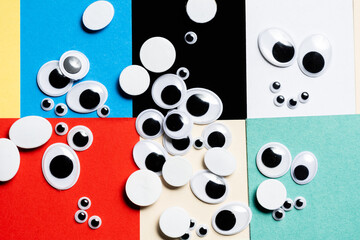 A bunch of toy eyes scattered against a multi-colored background