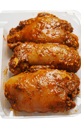 Raw uncooked Asian spice marinated chicken fillets in a plastic tray. Poultry product. Meat industry, Summer barbecue range. Meat in marinade with herb, oils and sauce.