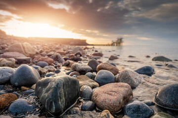 Colorful rocks of Salthill beach in focus. Blackrock diving board out of focus. Sun rise time. Sun...