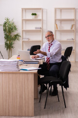 Old businessman employee sitting in the office