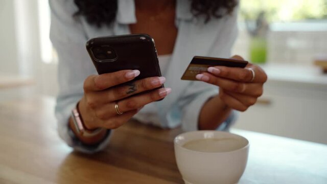Mixed race female making online payment with cellular device and credit card 