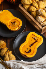 Pumpkin cream soup served in butternut squash with pumpkin shaped buns and pumpkin oil