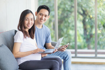 Pregnant parents are using a laptop to view ultrasound images of their unborn child.