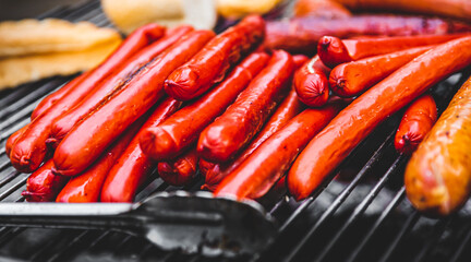 Grilling sausages on barbecue grill outdoor