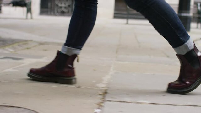Profile shot of feet walking on the city streets, in slow motion