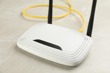 Modern Wi-Fi router on light grey marble background