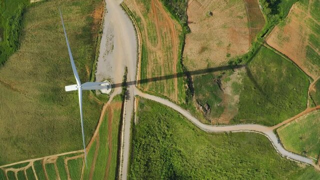 Aerial top view of windmills rotating by the force of the wind for generating clean renewable energy for sustainable development in a green ecologic way at highland. Bird&rsquo;s eye view shot by drone.