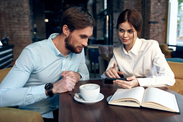business man and woman are sitting at the table in a cafe communication work colleagues