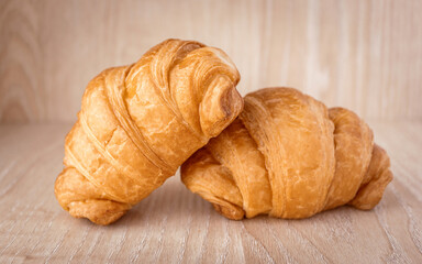 Close up of fresh delicious croissants on wooden background