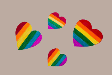paper cutout hearts in Colors of the rainbow flag are laid out on the gray background. LGBT social movements concept..
