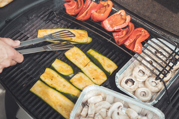 Vegetarian BBQ on weekend. Grill cheese and vegetables on gas grill. Outdoors.
