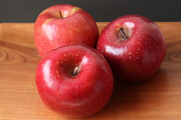 Fuji apples on a wooden plate, isolated