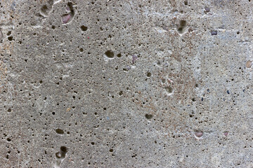A flat grey concrete textured surface covered in air bubbles