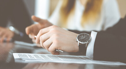 Obraz premium Unknown business people discussing questions of contract at meeting in modern office, close-up. Teamwork and partnership concept