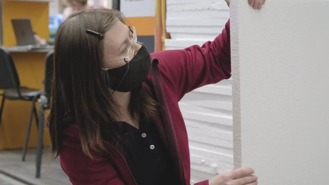 Woman wearing a mask against the virus buy white styrofoam for repairs in a building materials store. Concept of women independence, feminism, gender equality, repair and construction