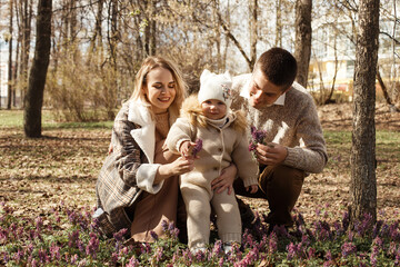 Fototapeta premium A young, beautiful couple is walking in the park with their little daughter.