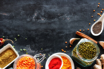 spicy spice herbs and condiments on black kitchen table with place for text